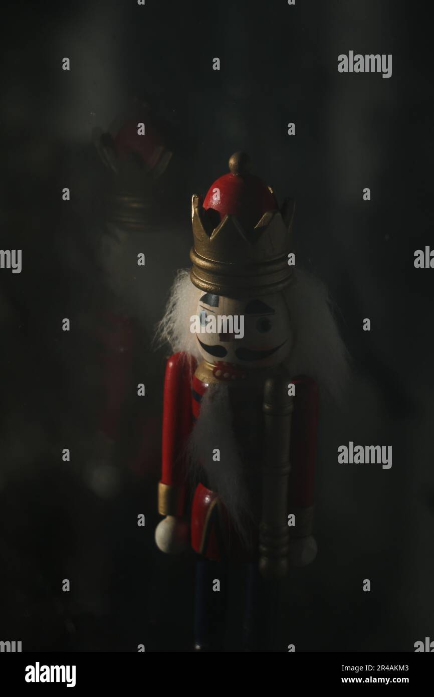 Un primo piano di una statuetta nutcracker su sfondo scuro Foto Stock