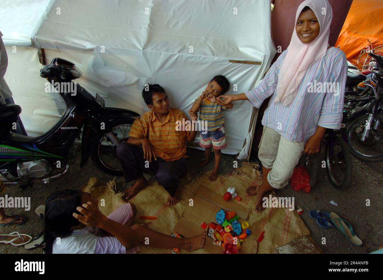 US Navy una famiglia indonesiana è lasciata senza casa dopo che lo tsunami ha colpito banda Aceh sull'isola di Sumatra, Indonesia. Le famiglie vivono fuori dalle tende in un campo di sfollati interni (IDP) vicino Foto Stock