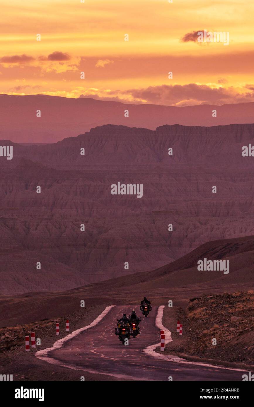 Lhasa, Regione autonoma del Tibet in Cina. 25th maggio, 2023. Tre motociclisti si dirigono verso la foresta terrestre nella contea di Zanda, nella regione autonoma del Tibet del sud-ovest della Cina, il 25 maggio 2023. Zanda è famosa per il paesaggio unico della foresta terrestre, che è stato formato da movimento geologico e l'erosione del suolo. Queste foreste sembrano giallastre, ma il colore varia in parti diverse. Credit: Fei Maohua/Xinhua/Alamy Live News Foto Stock
