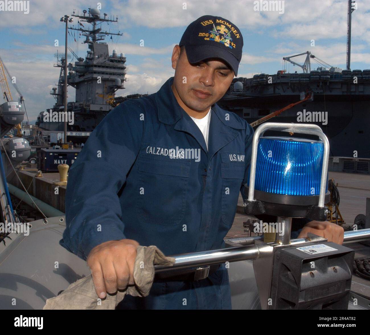 US Navy Seaman assegnato al cacciatorpediniere missilistico guidato USS Momsen (DDG 92), pulisce il sistema di illuminazione di polizia a bordo di una delle sette metri rigida Hull Inflatable Boats (RHIB) della nave. Foto Stock