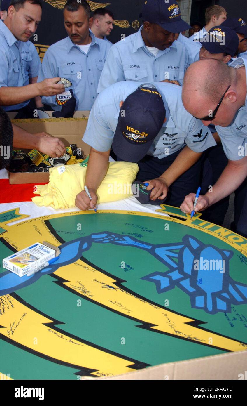 I marinai DELLA Marina STATUNITENSE precedentemente assegnati allo Squadron Eleven (HC-11), firmano la vecchia cresta dello squadrone HC-11 dopo essere stati rimessi in servizio. Foto Stock