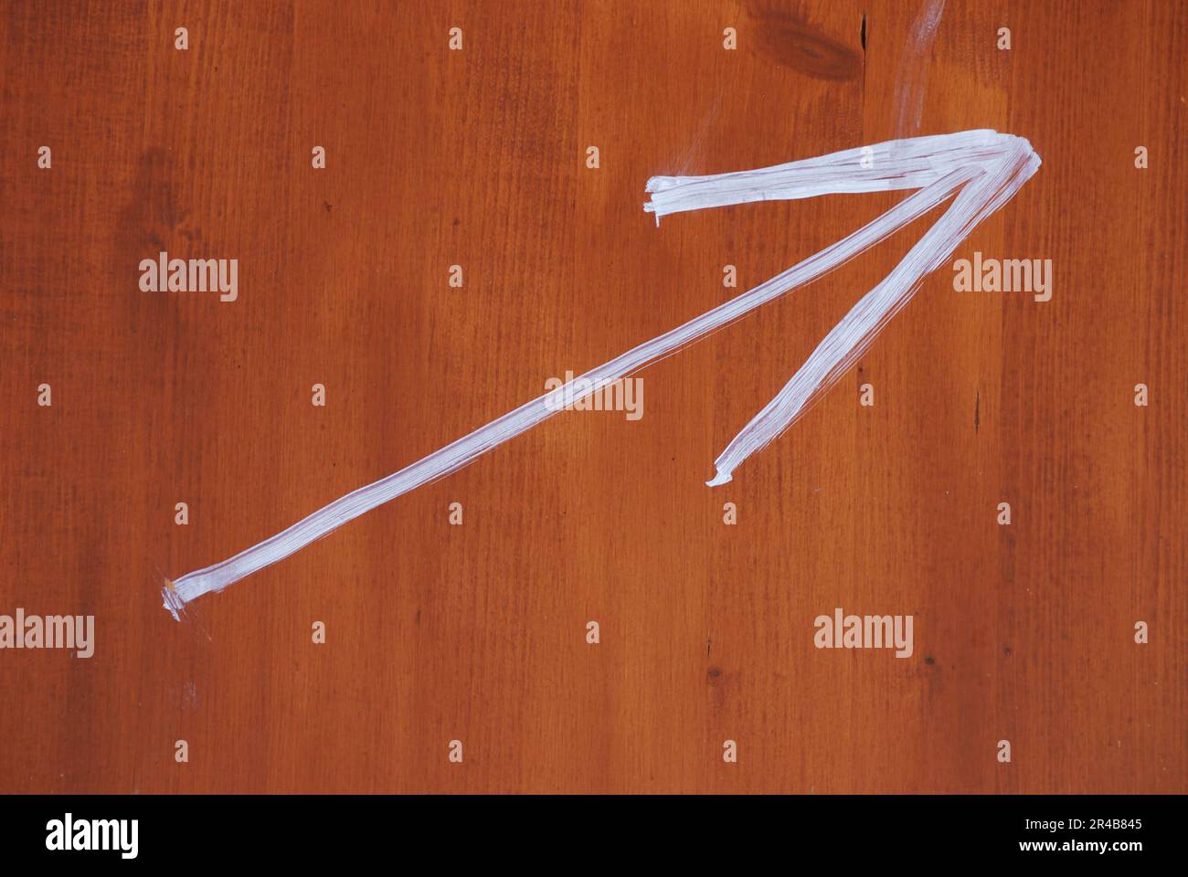 Freccia dipinta su una tavola di legno Foto Stock