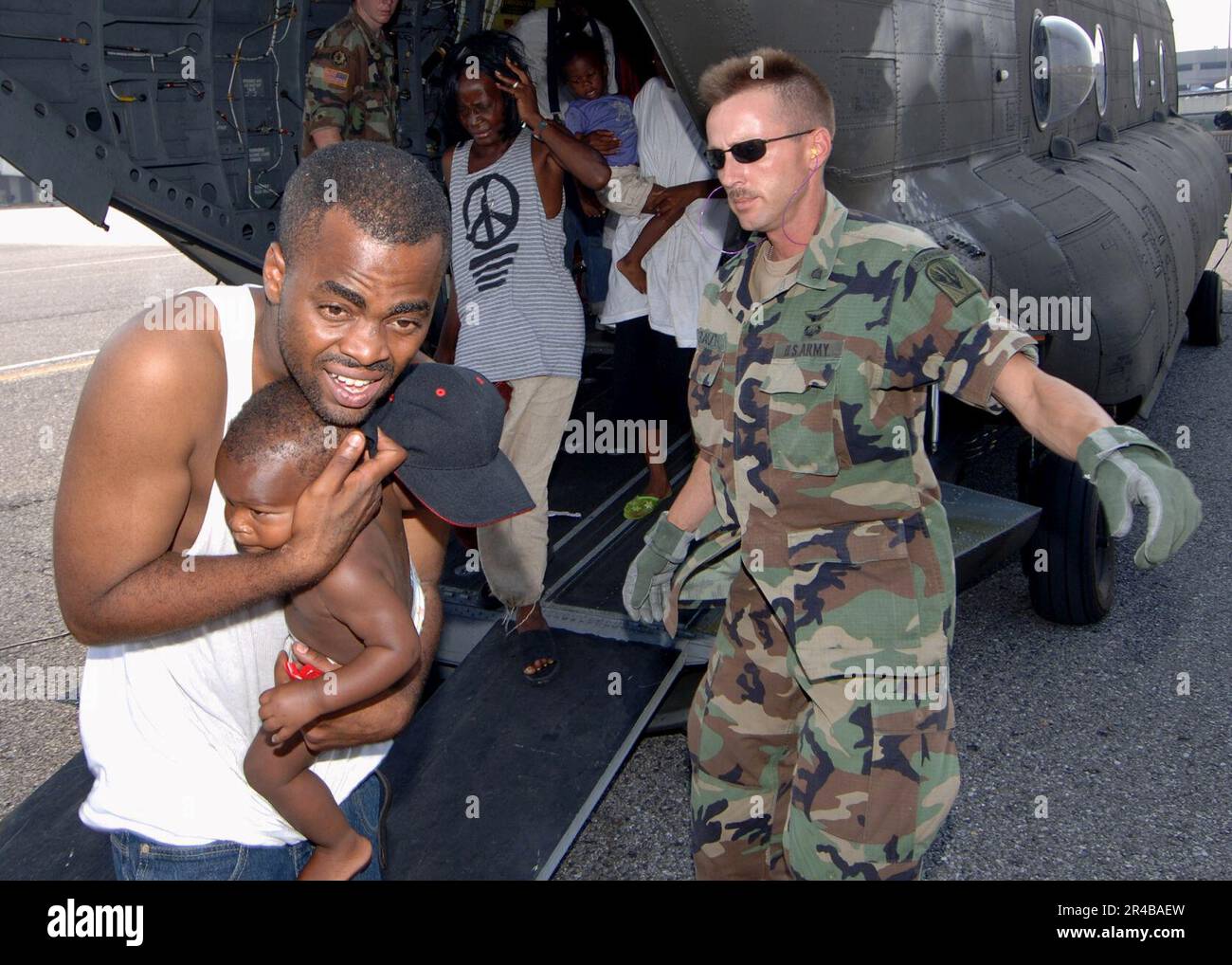US Navy un equipaggio aereo della Guardia nazionale dell'esercito dirige le vittime dell'uragano Katrina mentre escono dalla parte posteriore di un elicottero Chinook dell'esercito CH-47 durante gli sforzi di soccorso a New Orleans. Foto Stock