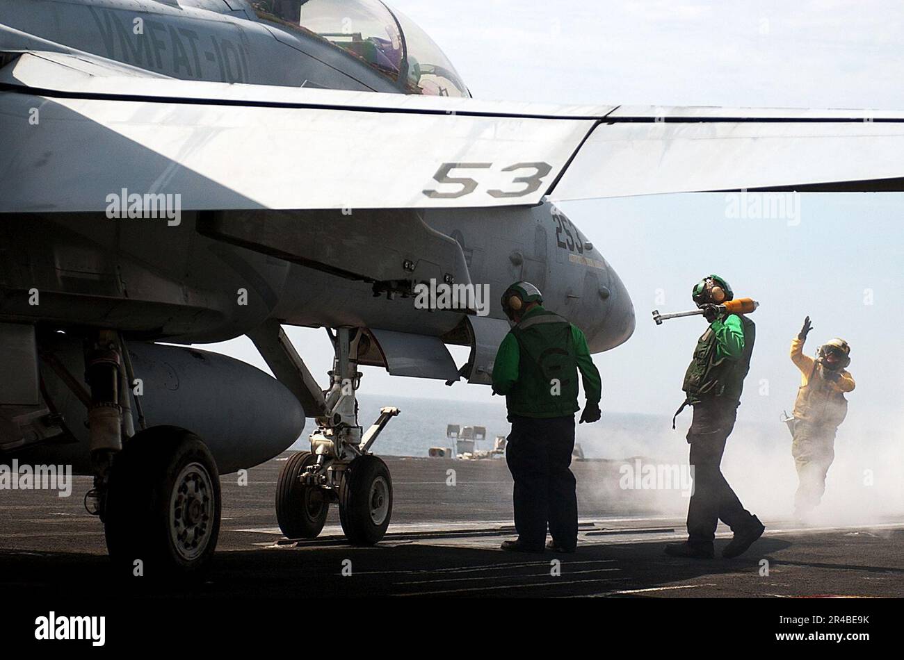 Il personale del ponte di volo della Marina DEGLI STATI UNITI prepara un F-A-18B Hornet, assegnato ai Sharp Shooters of Marine Fighter Attack Training Squadron One Zero One (VMFAT-101), per il lancio. Foto Stock