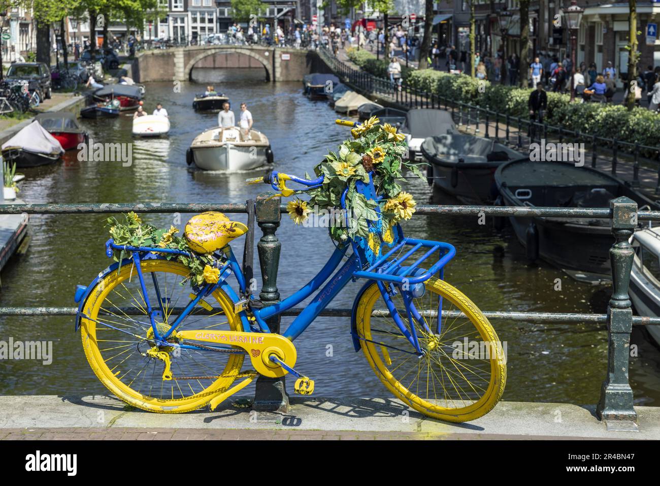 Bicicletta in blu e giallo, su un canale, Amsterdam, capitale dei Paesi Bassi, Olanda, Europa occidentale Foto Stock
