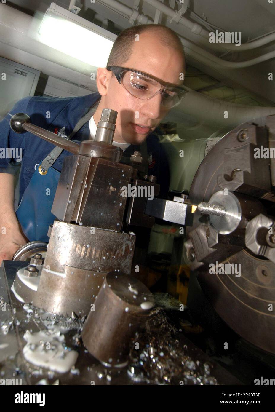 US Navy Machinery Repairer 2nd Class trasforma un blocco di montaggio della piegatubi Hossfeld su un tornio a bordo della portaerei Nimitz USS Theodore Roosevelt (CVN 71). Foto Stock