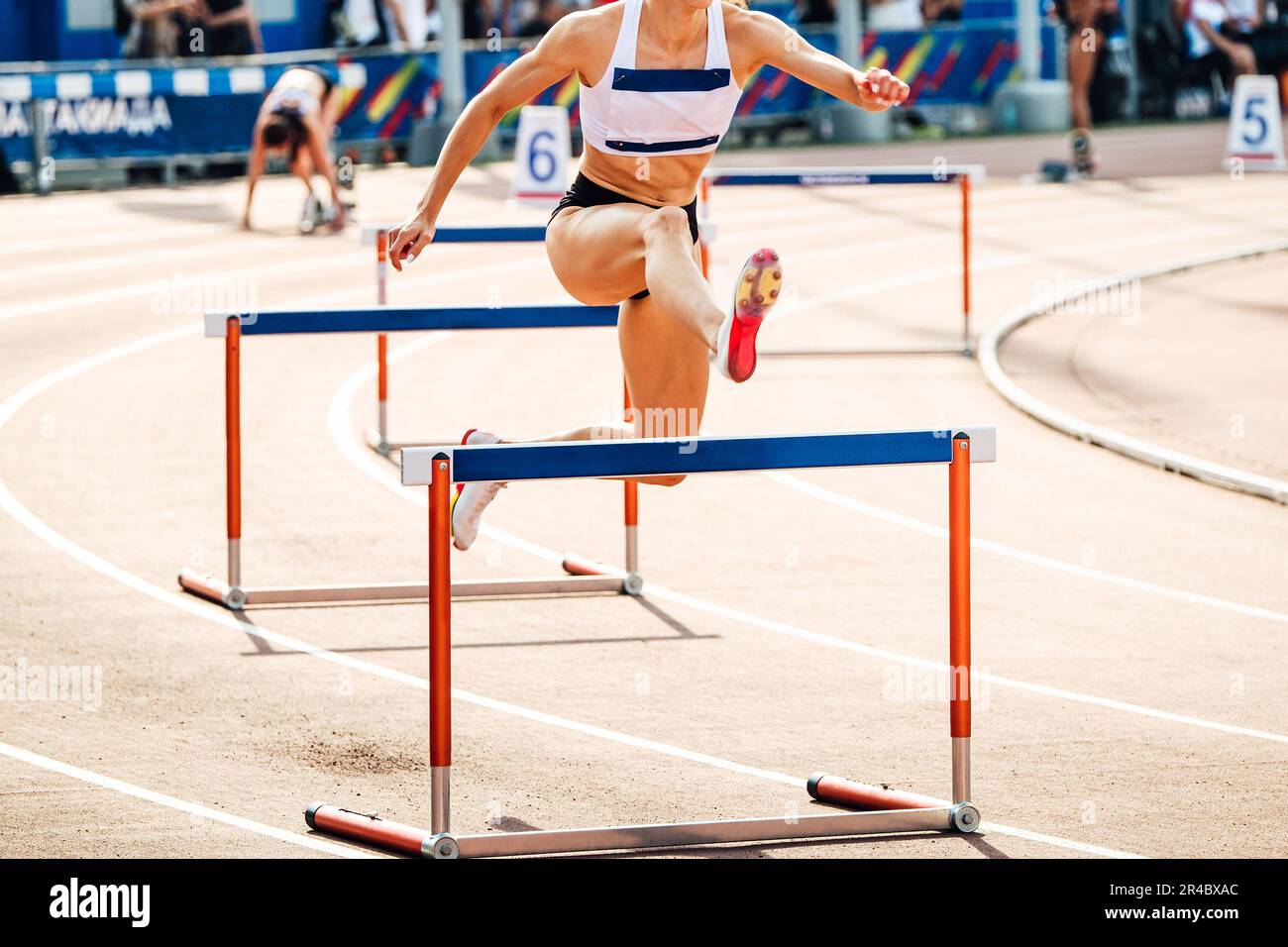 atleta femminile che corre 400 metri ostacoli gara nei campionati estivi di atletica Foto Stock