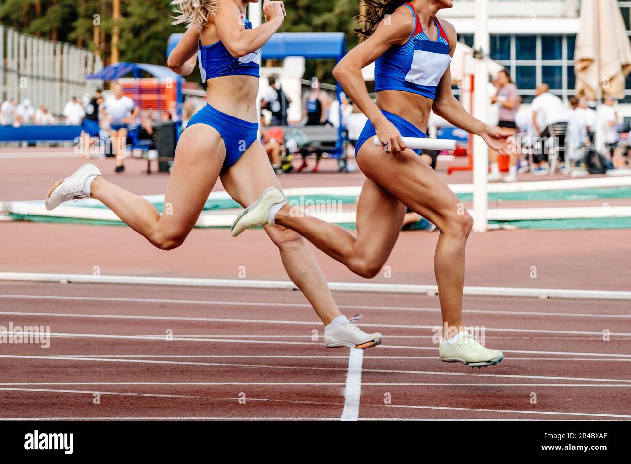 running donne pista e campo squadra relè gara 4 x 100 metri nei campionati di atletica estiva Foto Stock
