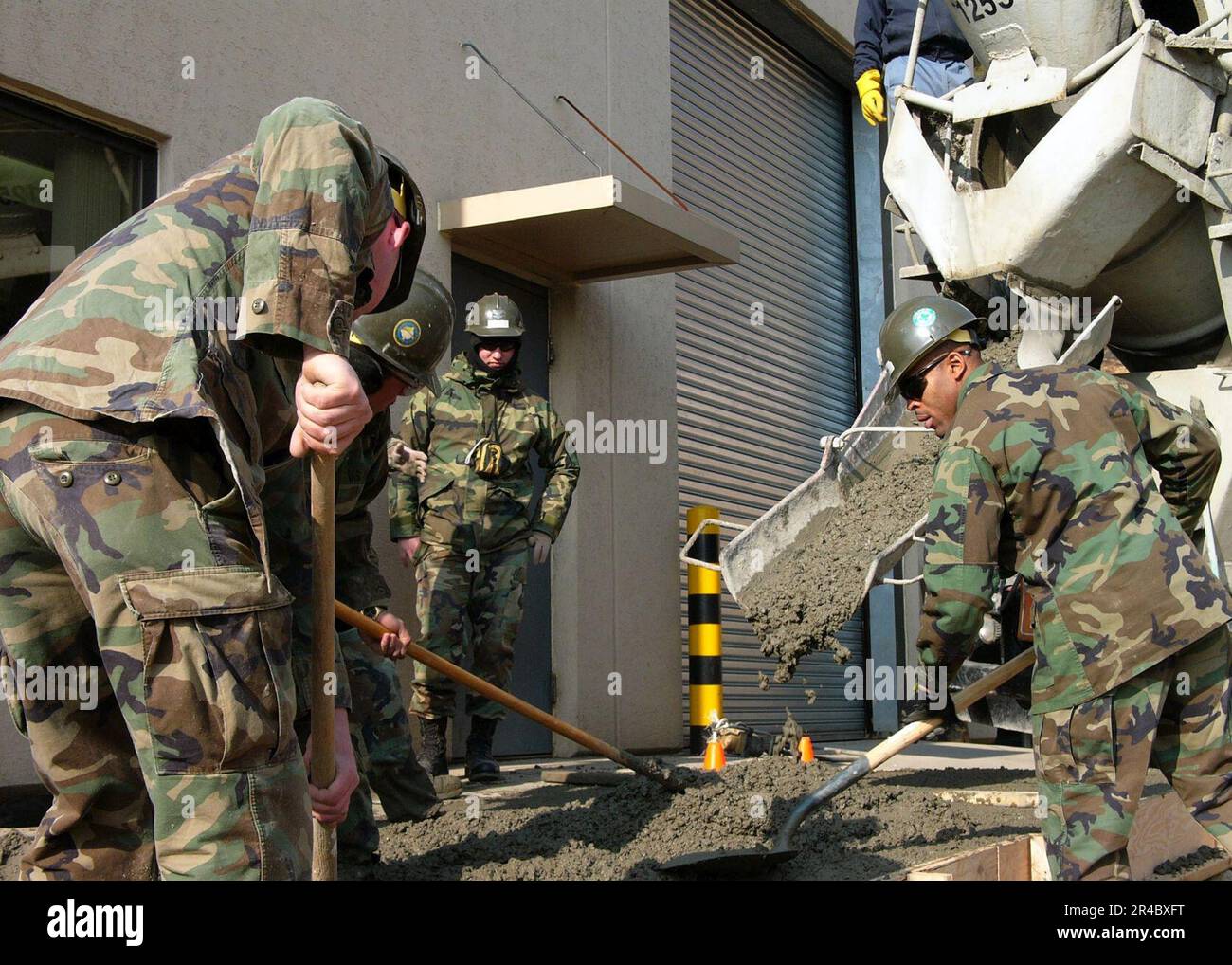 US Navy Seabees assegnato a Naval Mobile Construction Battalion Four (NMCB-4), Det Corea, posa cemento per un progetto patio. Foto Stock