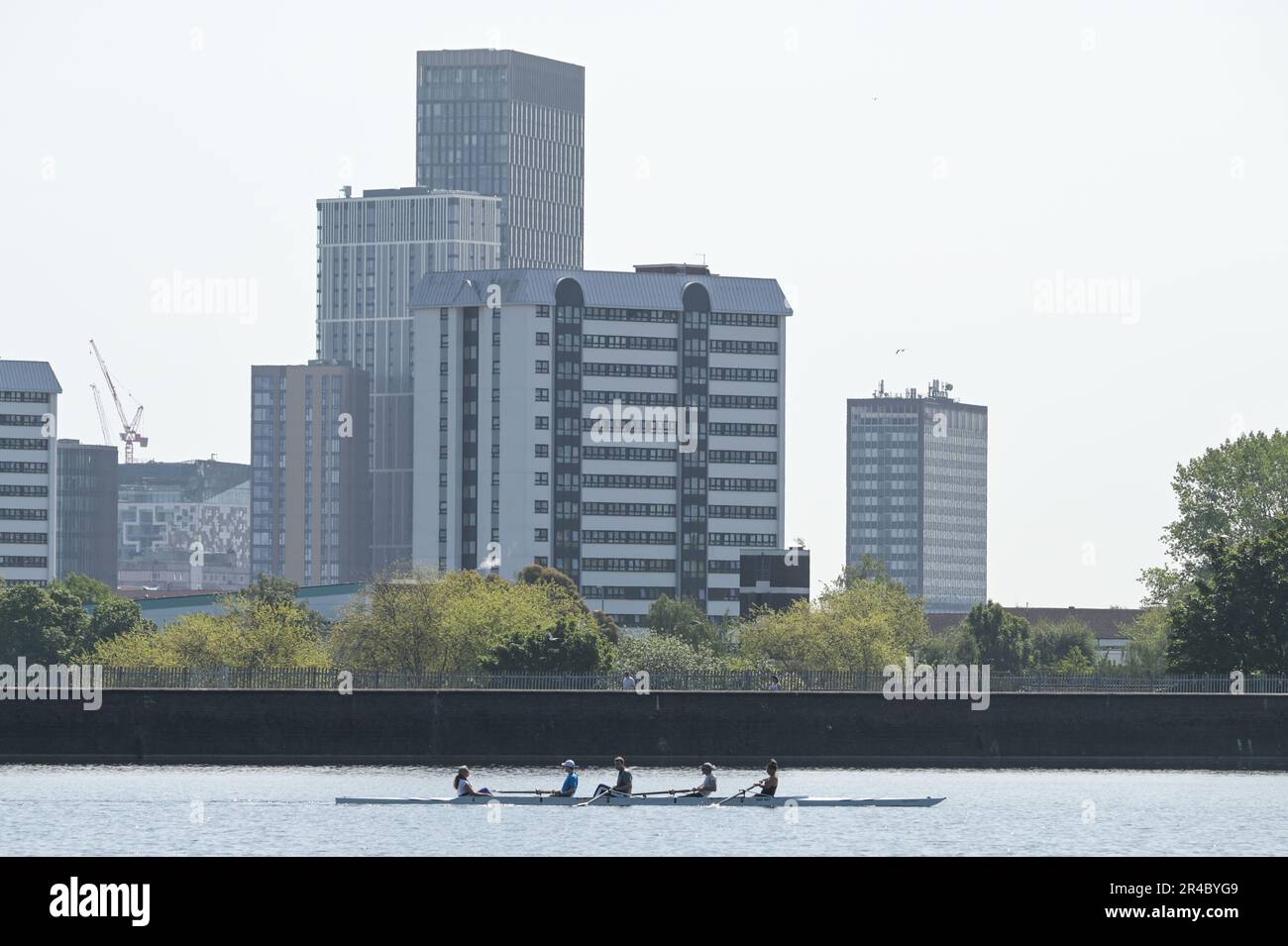 Edgbaston Reservoir, Birmingham, 27th maggio 2023 - gli appassionati di sport acquatici si sono recati a Edgbaston Reservoir il sabato mattina per godersi le temperature calde durante il weekend di Spring Bank Holiday. Diversi amanti del sole hanno utilizzato barche a vela e a remi per attraversare le acque scintillanti con lo skyline di Birmingham che incombe sullo sfondo. Un windsurfer inoltre ha usato la piccola quantità di vento per divertirsi al sole. Credit: Stop Press Media/Alamy Live News Foto Stock