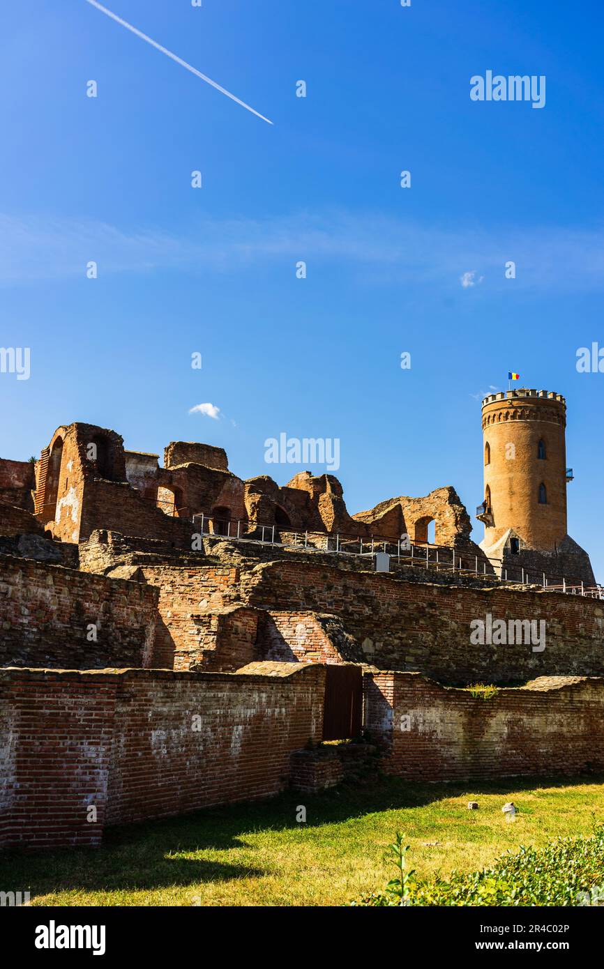 Un maestoso vecchio castello arroccato sulla cima di una collina che domina un fiume che si snoda attraverso un lussureggiante paesaggio verde Foto Stock