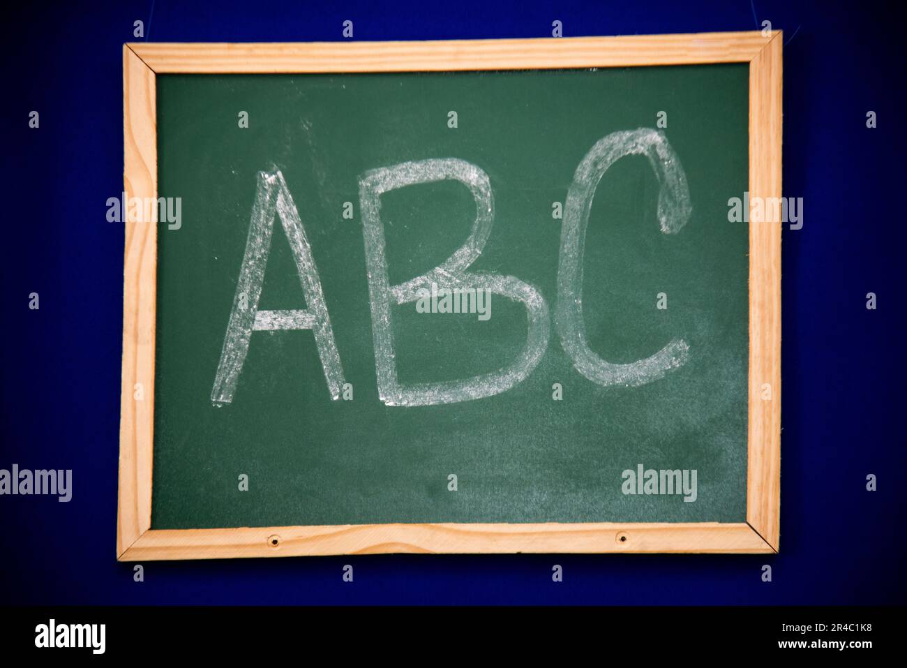 Una vista ravvicinata di una lavagna con un ABC stilizzato scritto in gesso bianco sulla superficie della lavagna Foto Stock