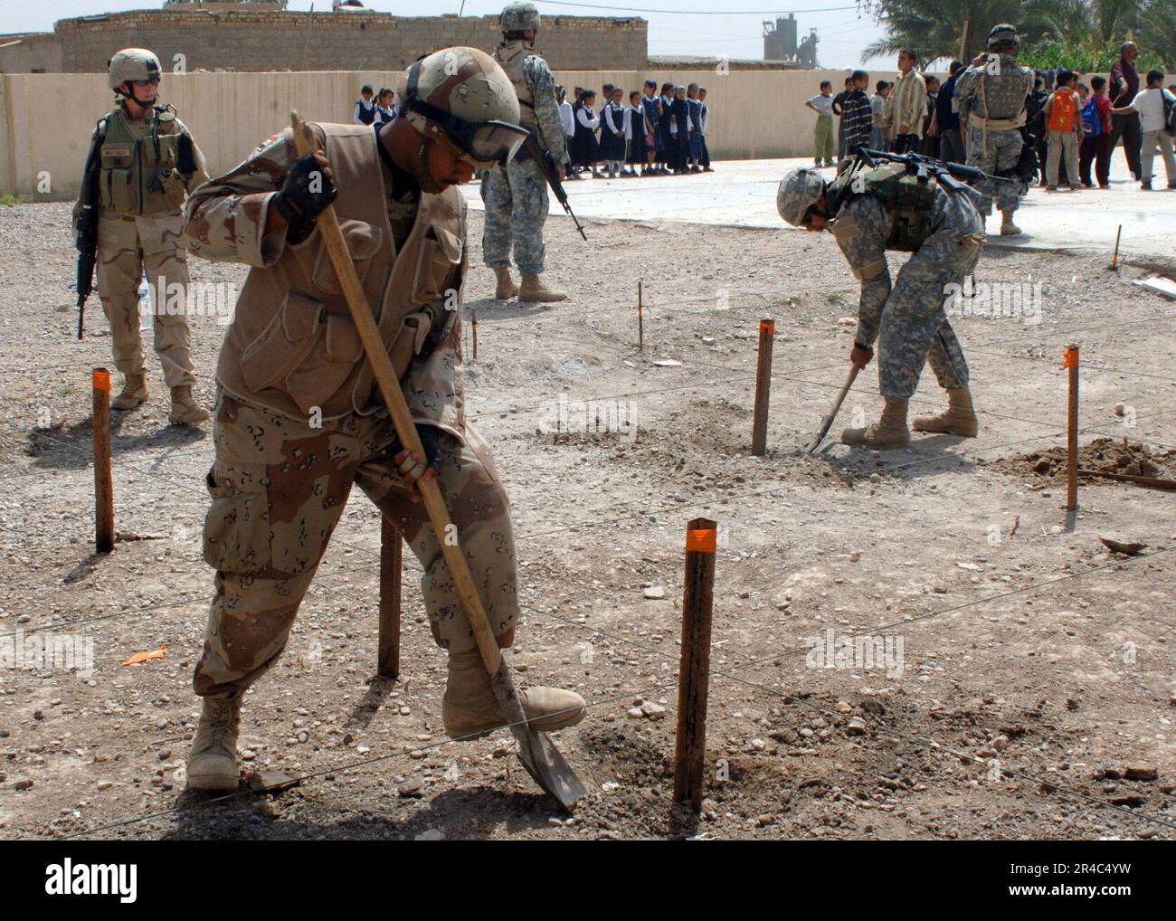 US Navy iracheno e Stati Uniti I soldati dell'esercito costruiscono la struttura per una fondazione di livello per un parco giochi donato da un'azienda americana in una scuola in Abraham Jaffas. Foto Stock