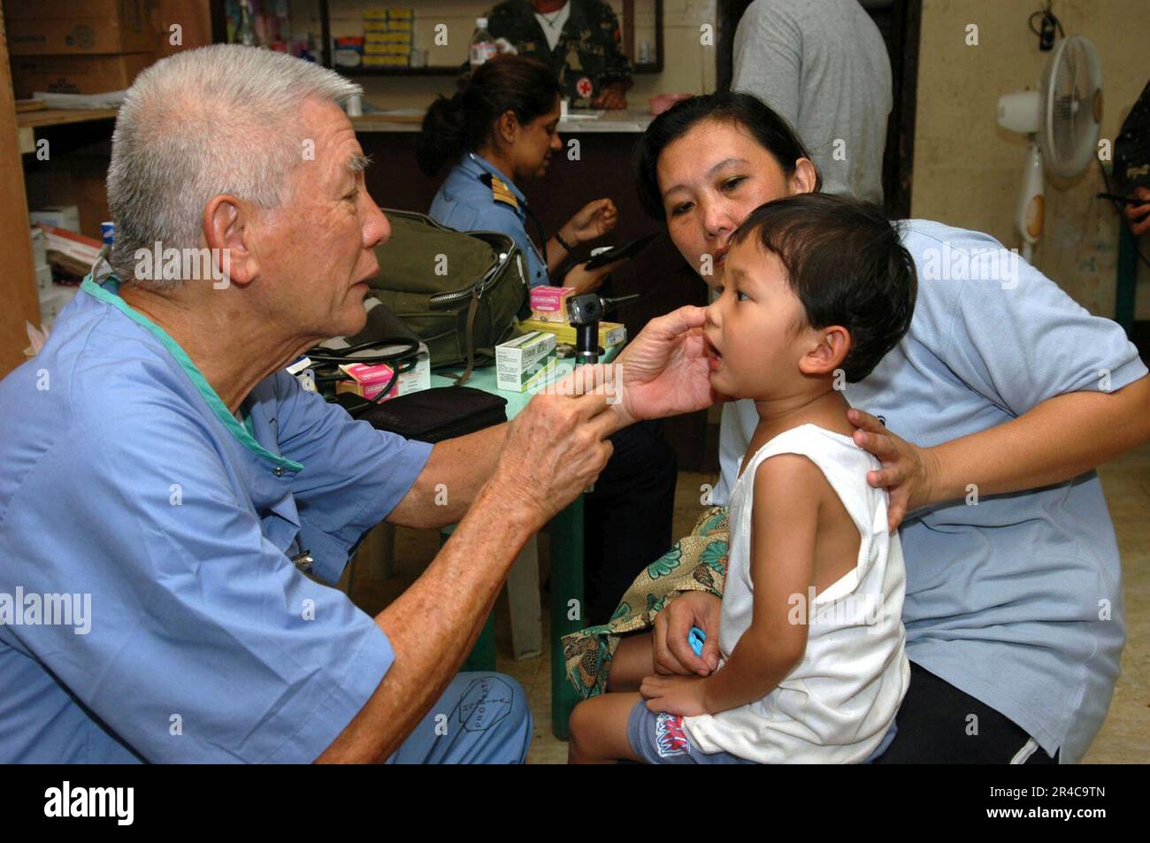 US Navy un medico con Aloha Medical Mission, esamina un ragazzo a Camp Batista durante un Medical and Dental Civil Action Project ospitato dagli Stati Uniti Comando militare di Sealift (MSC) nave ospedaliera USNS. Foto Stock
