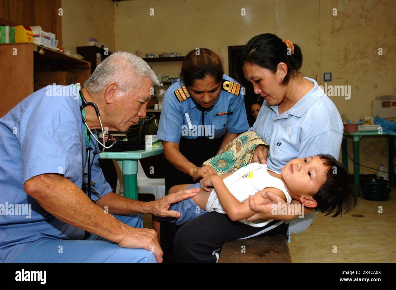 US Navy un medico con Aloha Medical Mission, e CMdR. Diviya Gautam, della Marina indiana, esamina un ragazzo per la diagnosi a Camp Batista durante un Medical and Dental Civil Action Project. Foto Stock