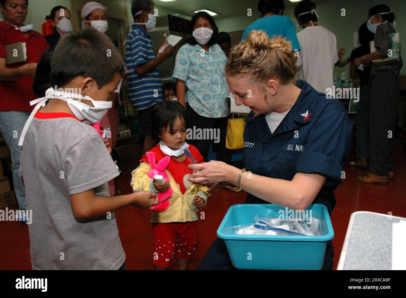 US Navy Navy Hospital Corpsman 2nd Class distribuisce spazzolini da denti ai bambini durante un Medical and Dental Civil Action Project tenutosi a bordo degli Stati Uniti Comando militare di Sealift (MSC). Foto Stock