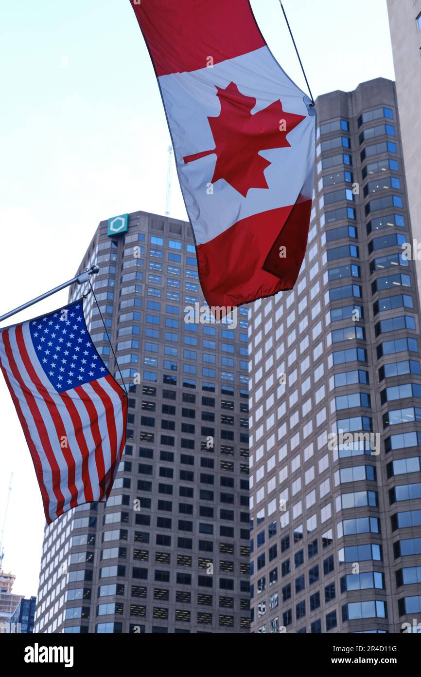 Bandiere canadesi e americane in un moderno paesaggio urbano nordamericano Foto Stock