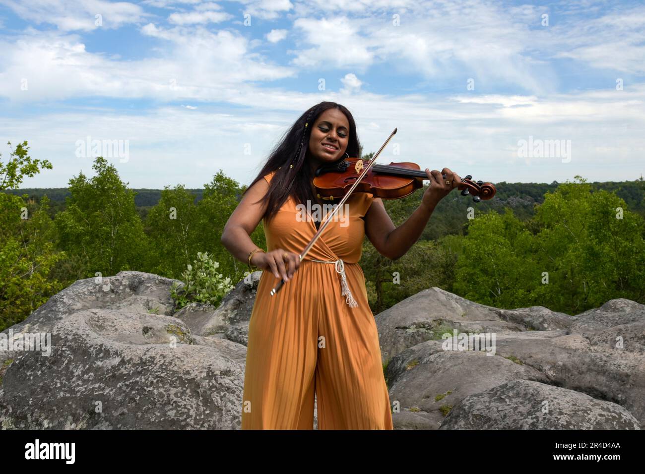 Bella donna nera che suona il violino nella foresta in Francia Foto Stock