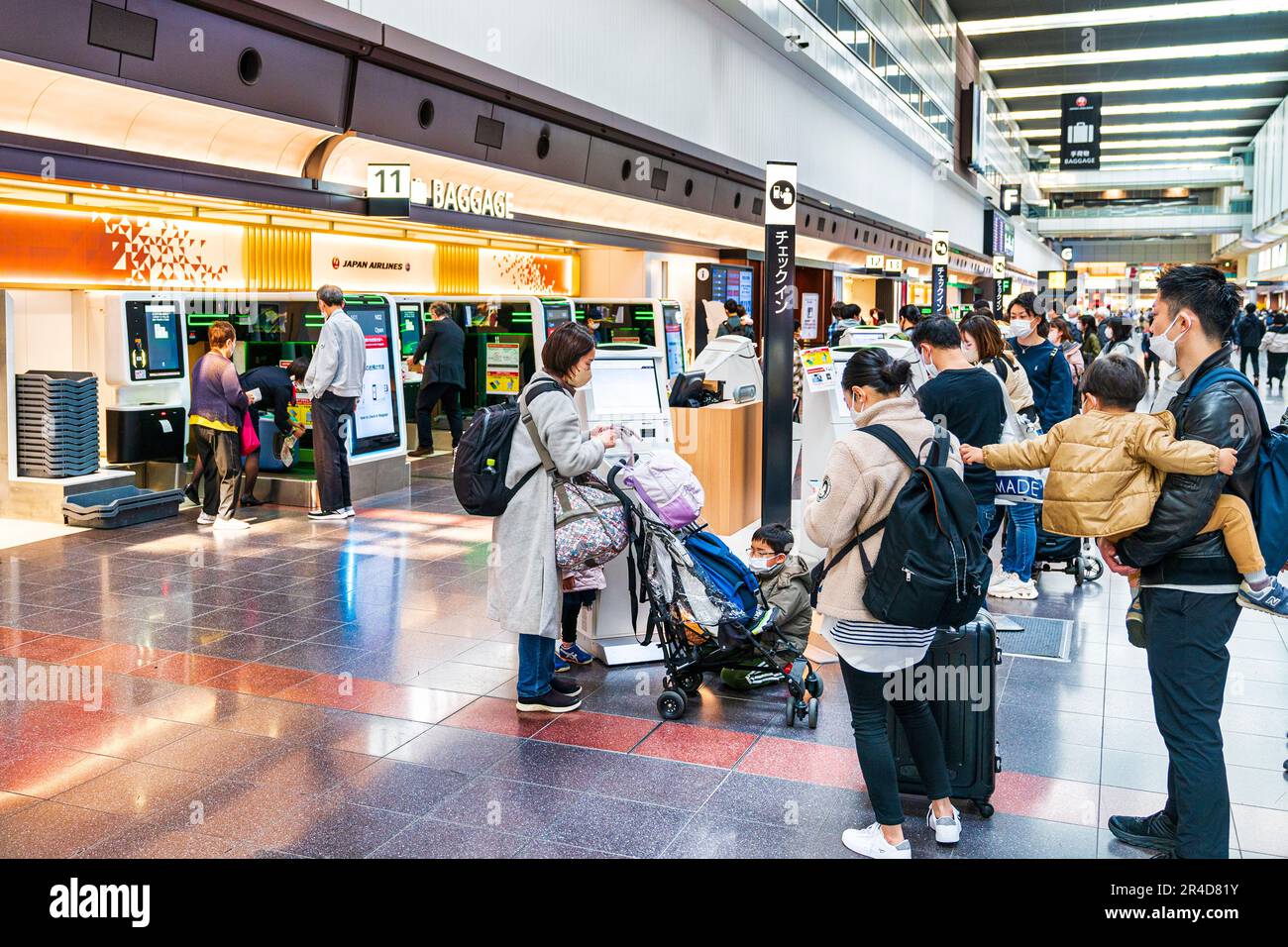 Persone che utilizzano le macchine self-service per il check-in dei bagagli nella zona japan Airlines del terminal nazionale 1 dell'aeroporto Haneda di Tokyo. Foto Stock