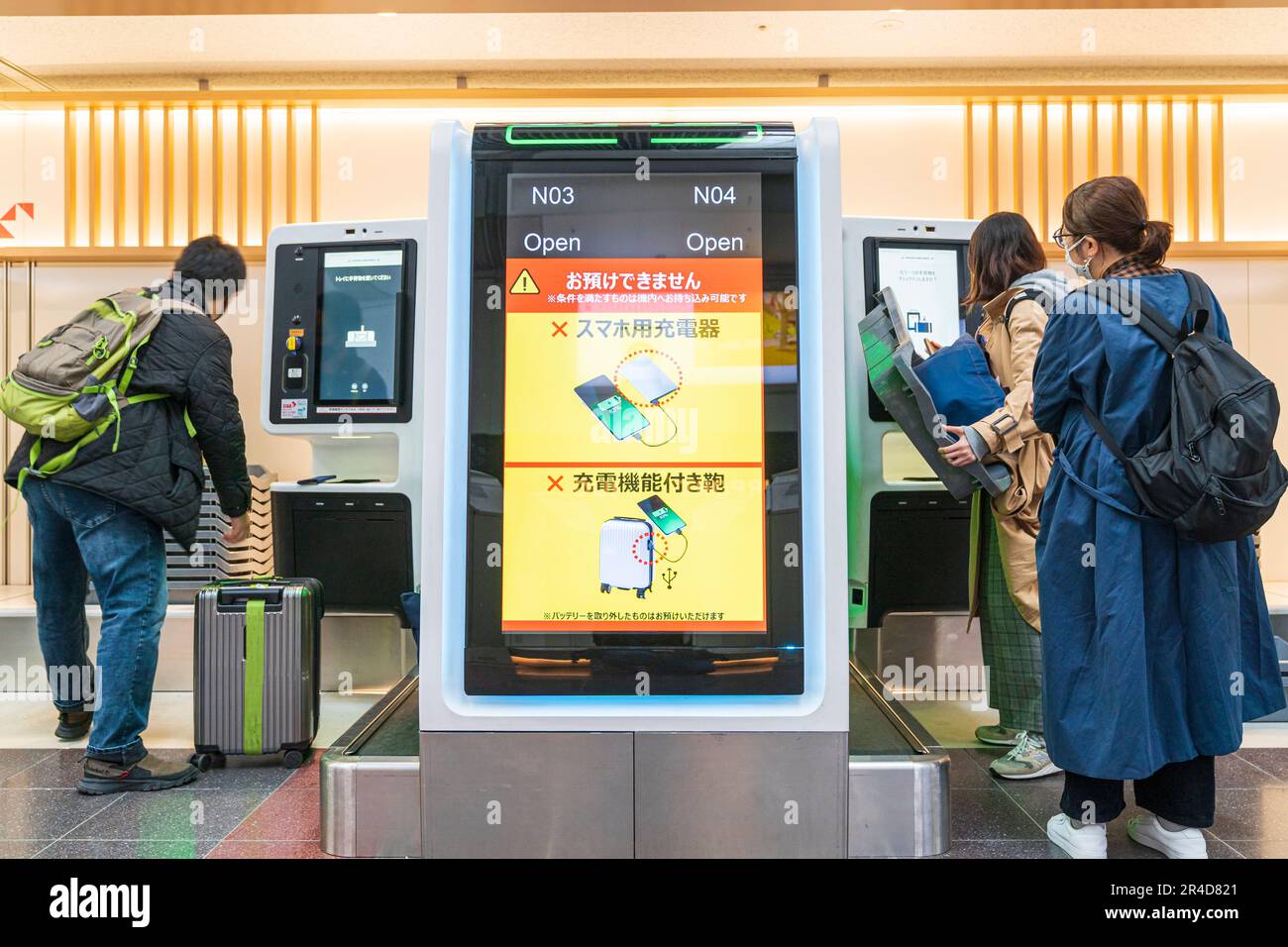 Check-in macchina bagagli con le persone che effettuano il check-in utilizzando la macchina tag bagagli dietro. Terminal uno nazionale, all'aeroporto Haneda di Tokyo. Foto Stock