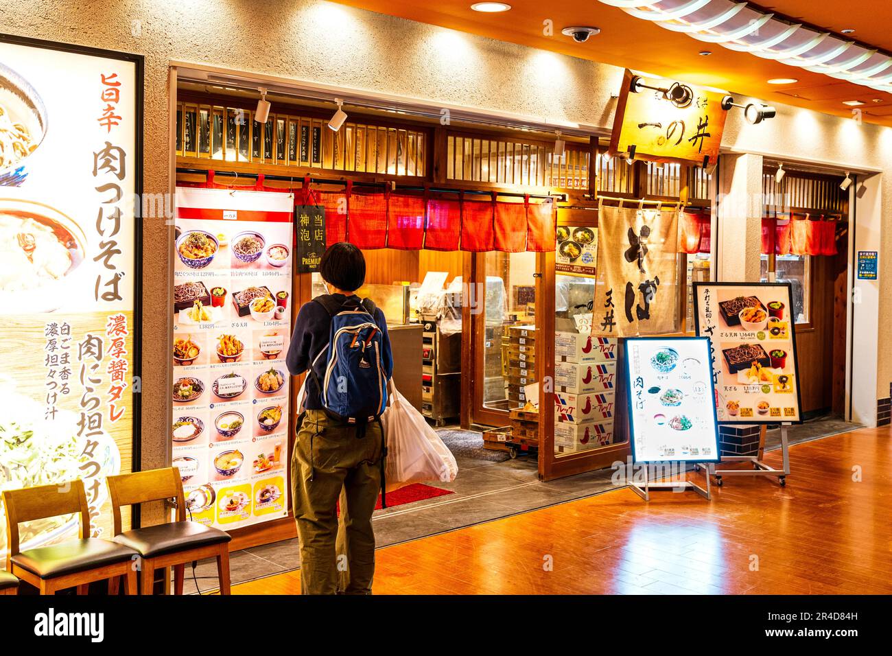 Ristorante Ichinoi Ramen noodle al terzo piano del terminal 1, aeroporto di Haneda. Uomo in piedi all'esterno che guarda il menu delle pareti, tende noren sopra l'entrata. Foto Stock