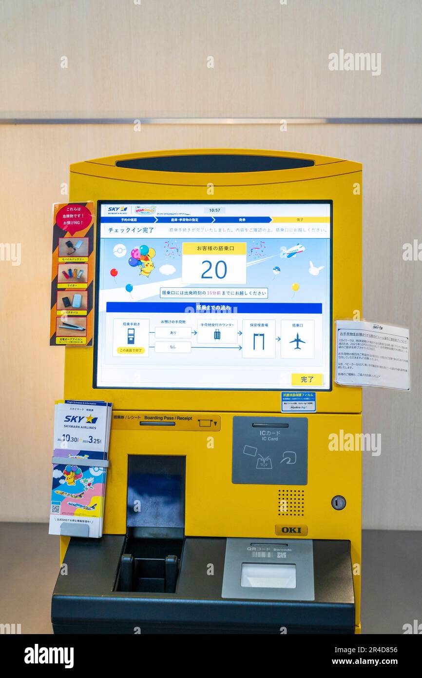 Primo piano di una macchina automatica con carta d'imbarco gialla OKI giapponese con schermo sul terminal nazionale 1 dell'aeroporto Haneda di Tokyo. Foto Stock
