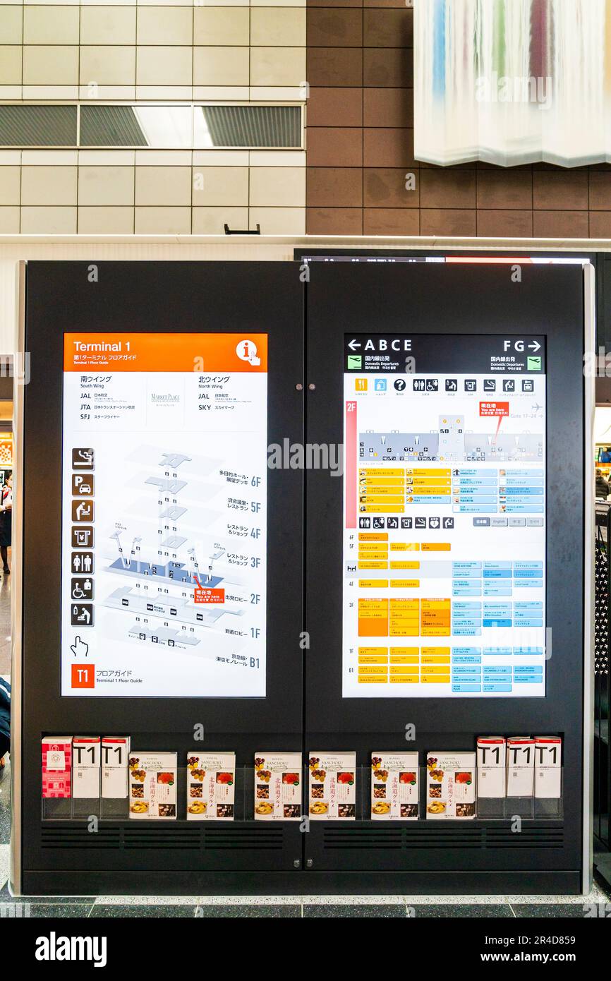 Il display luminoso mostra la mappa e lo schema del Terminal 1 dell'aeroporto di Haneda. Opuscoli in basso nel rack, sopra la mappa e le visualizzazioni degli elenchi. Foto Stock