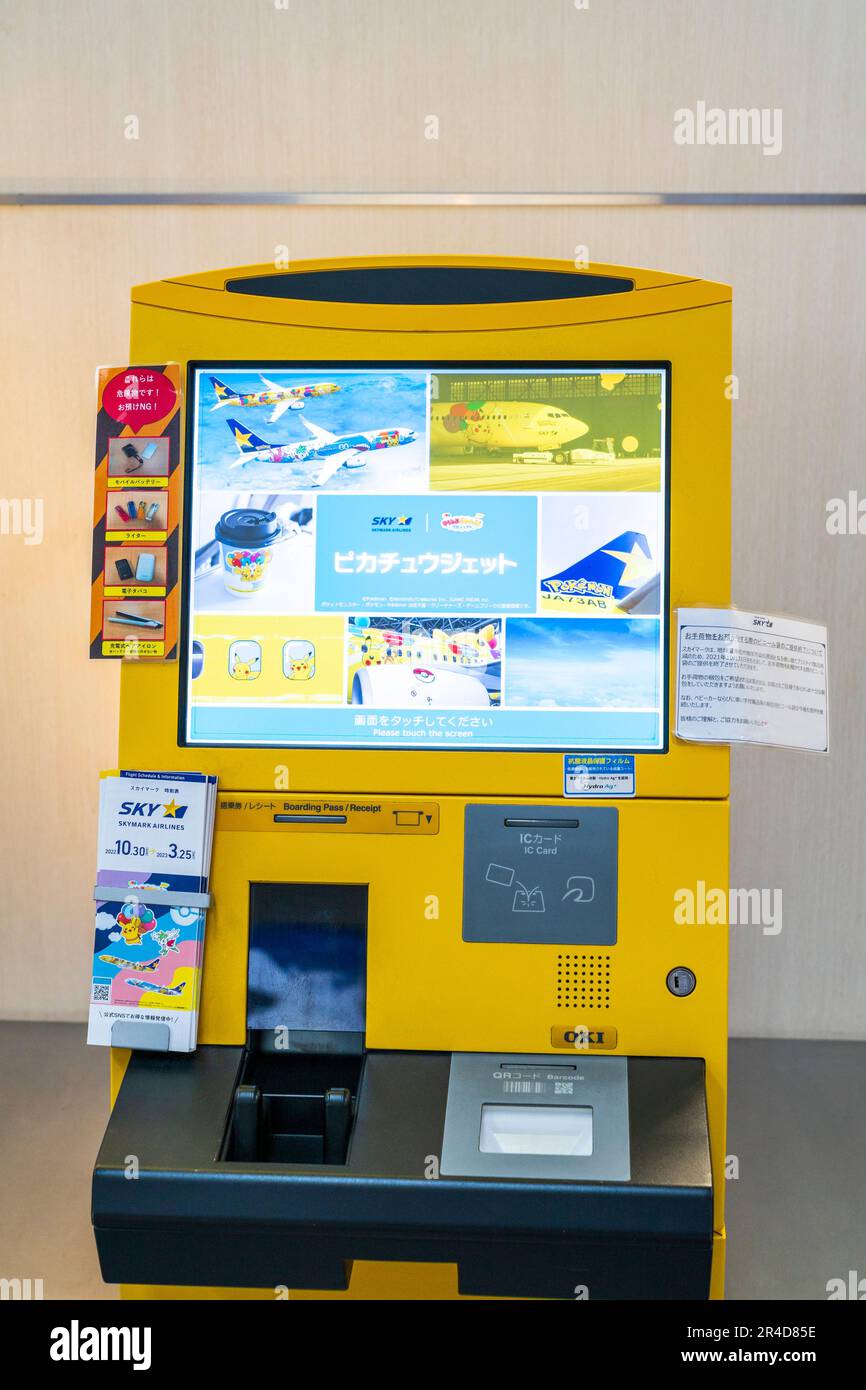 Primo piano di una macchina automatica con carta d'imbarco gialla OKI giapponese con schermo sul terminal nazionale 1 dell'aeroporto Haneda di Tokyo. Foto Stock