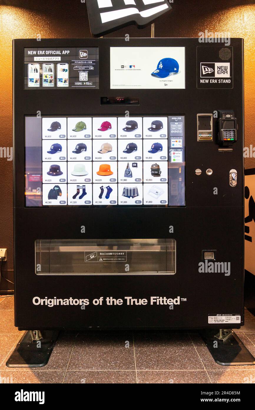 Stand New era, distributore automatico nero che vende berretti da baseball, borse e calze New era, all'aeroporto Haneda di Tokyo. Foto Stock