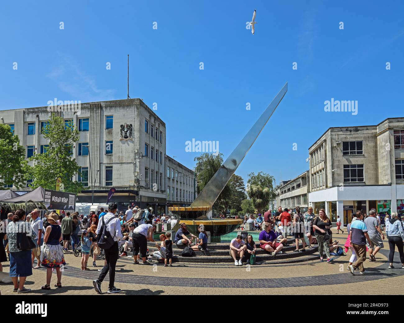 I visitatori e la gente del posto riposano intorno alla meridiana accanto alla Piazza al Flavour Fest annuale di Plymouth in Armada Way il fine settimana delle festività di maggio. Alcuni riposano Foto Stock