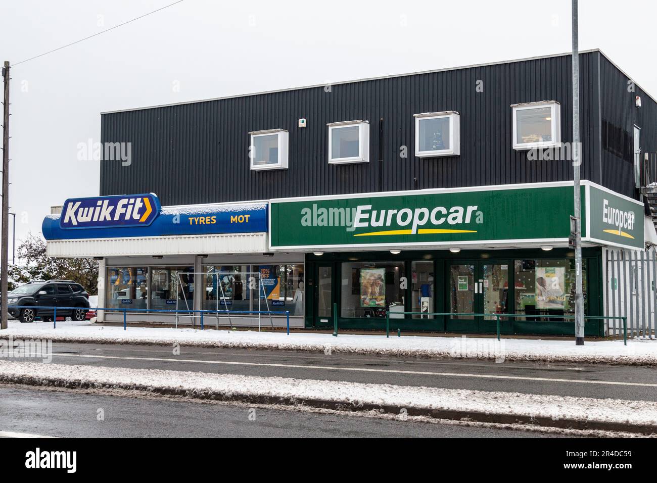 Una vista esterna di Kwik Fit e Europcar su Newmarket Road, Cambridge, Regno Unito in una giornata invernale innevata. Foto Stock