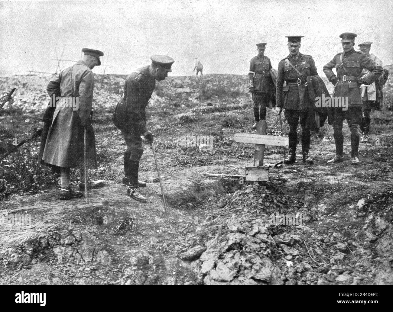 ''Autour de la Bataille; le roi George V avait tenu a se rendre au milieu de ses jeunes armees victorieuses. Parcourant le Champ de bataille, il se penche, ici, sur une tessere britannique au-dessus de laquelle se lit ce seul mot poignant: "Sconosciuto"---inconnu ! ', 1916. From "l'Album de la Guerre 1914-1919, Volume i" [l'Illustration, Paris, 1924]. Foto Stock