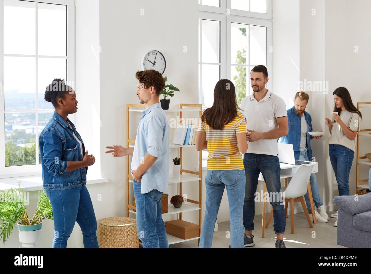 Gruppo multirazziale di bei giovani divisi in coppie per risolvere un compito creativo in ufficio. Foto Stock