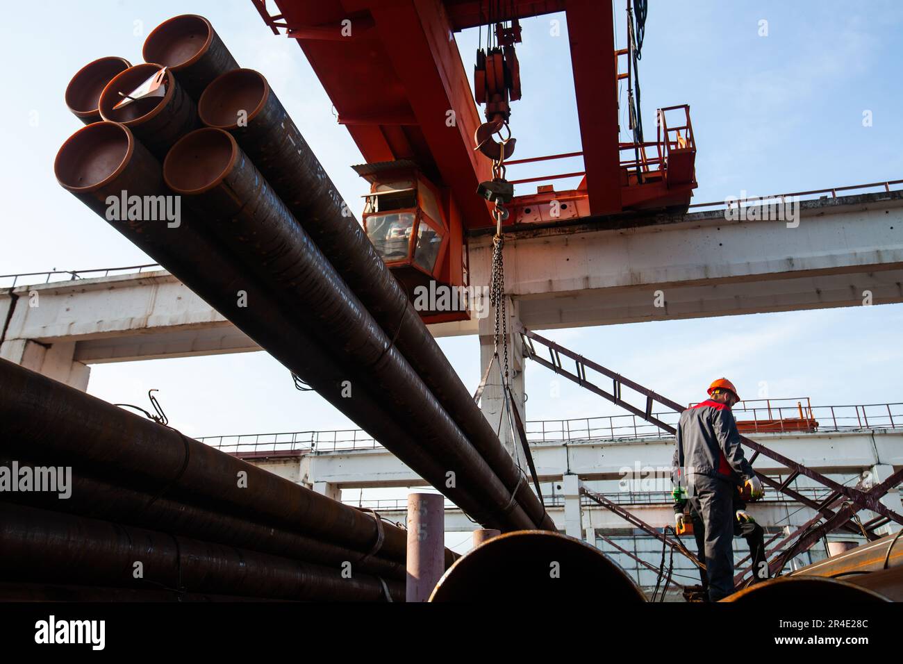 Podolsk, provincia di Mosca - 02 agosto 2021: I lavoratori caricano tubi con carroponte. Foto Stock