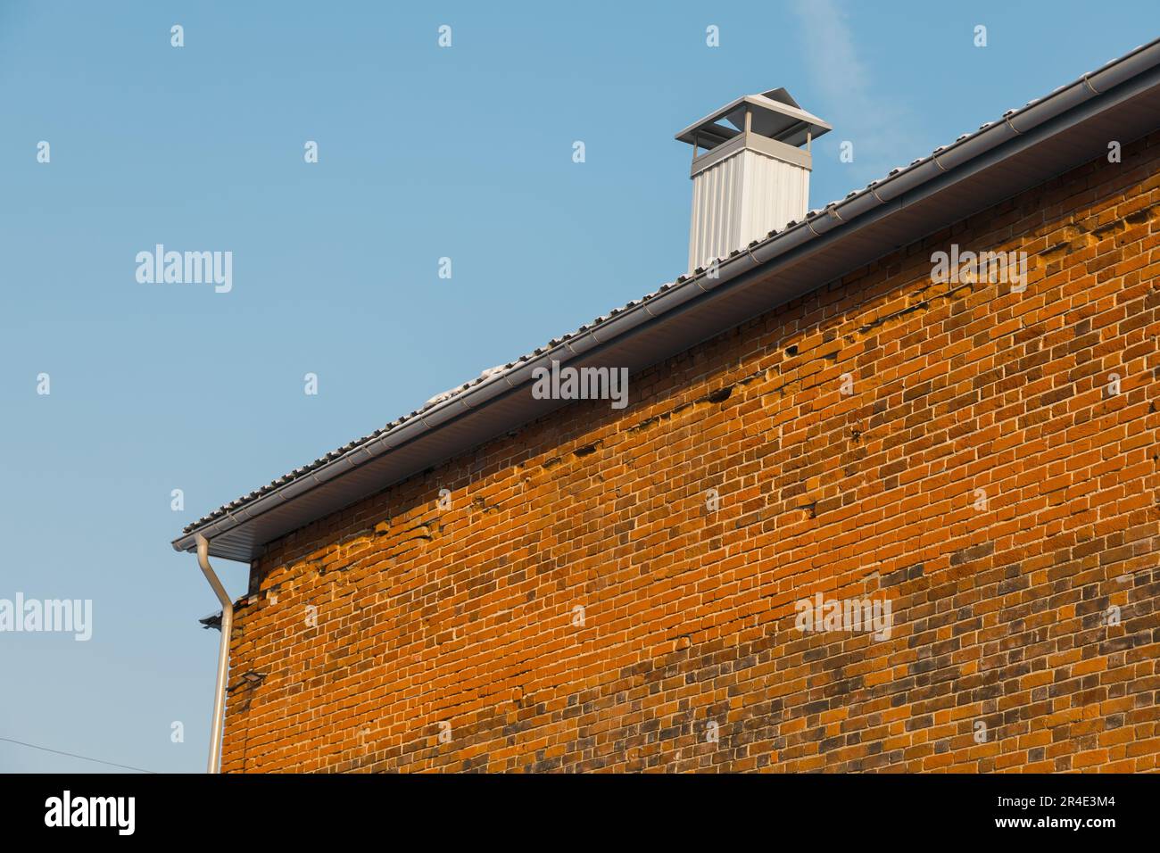 Primo piano camino sul tetto e cielo, muro di mattoni di casa Foto Stock