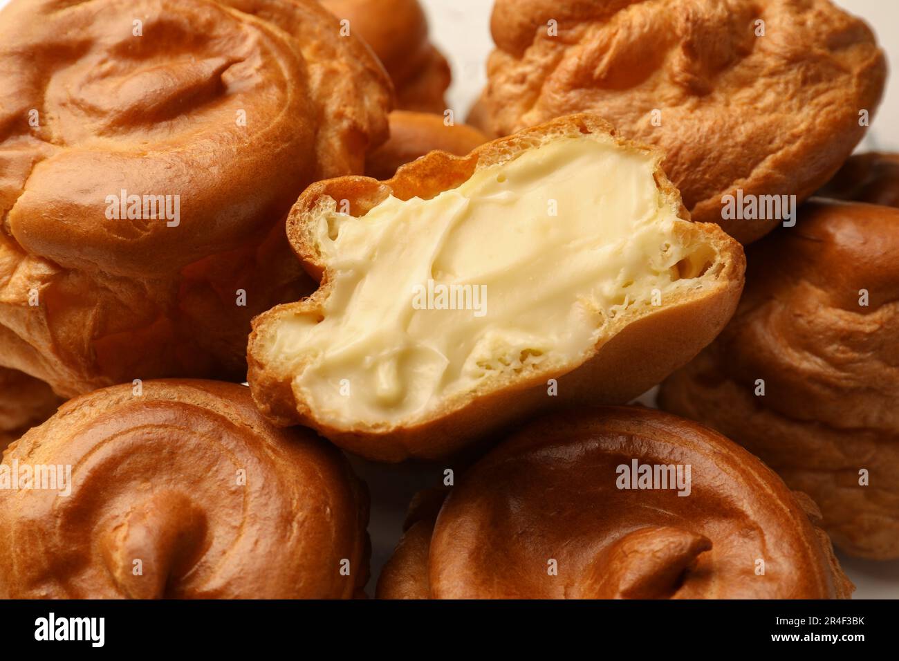 Deliziosi profiteroles con crema ripiena all'interno, primo piano Foto Stock
