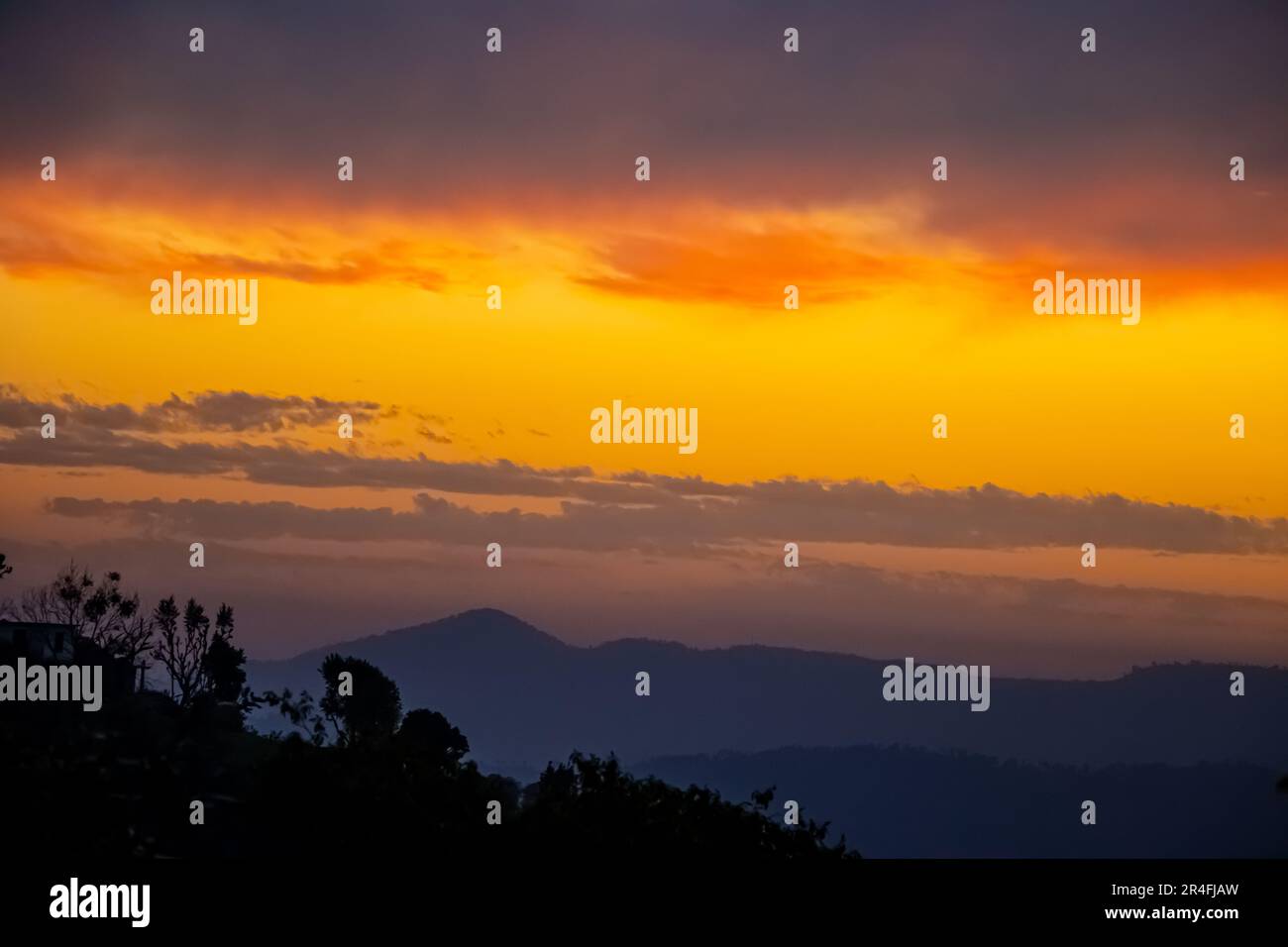 foresta contro Panorama colorato magnifico tramonto in campagna sopra colline e campi, bellezza sfondo natura e nuvole cielo Foto Stock