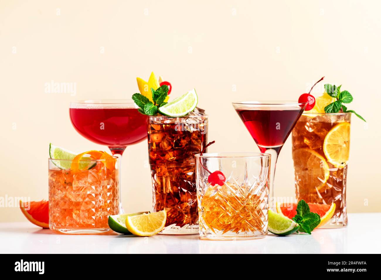 Set estivo di cocktail: Rum cola, tè ghiacciato lungo isola, manhattan, cosmopolita, vecchio stile - bevande popolari per cocktail party. Dorso beige Foto Stock