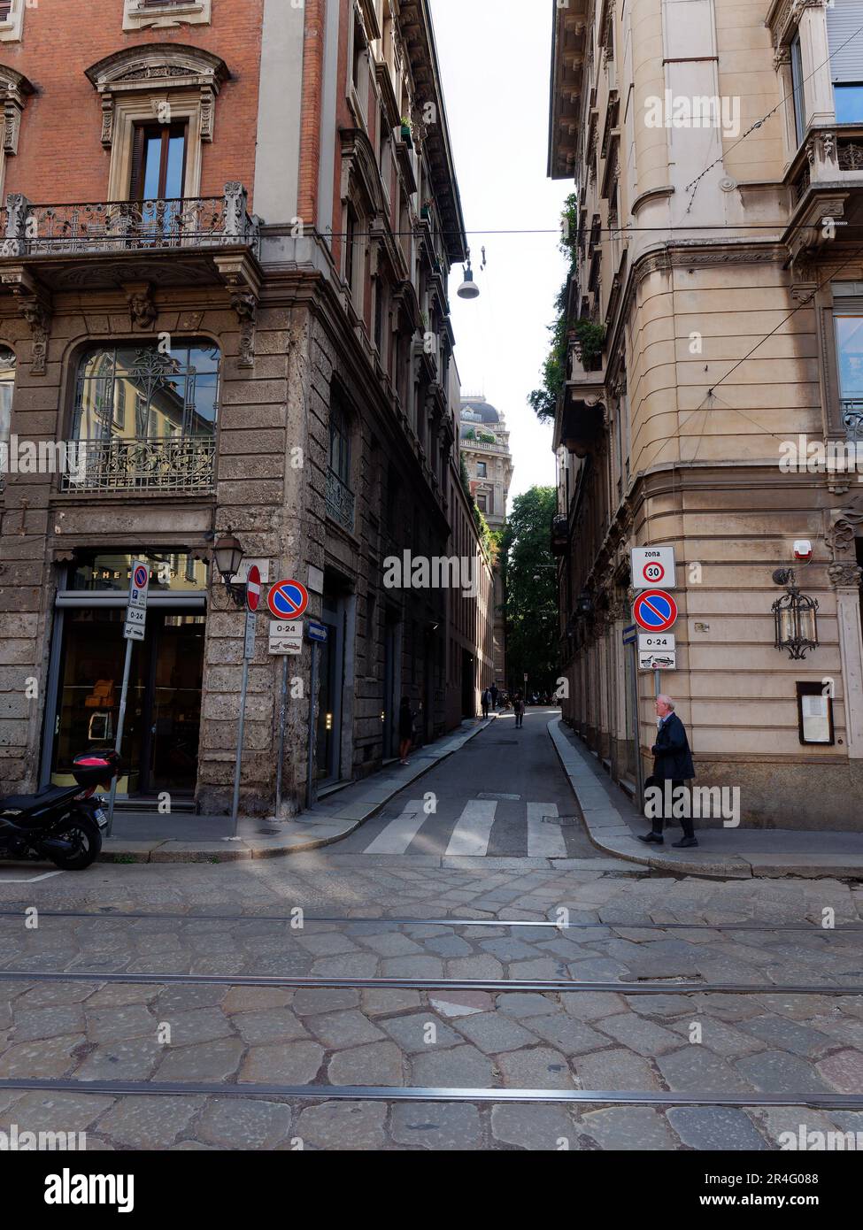 Pedonale accanto ad un passaggio pedonale su una stradina stretta con eleganti proprietà con balconi nel quartiere Brera di Milano, Lombardia, Italia Foto Stock