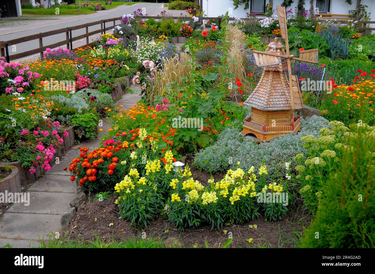 Baden-Wuerttemberg, Foresta Nera giardino cottage, giardino perenne, vari fiori da giardino, grano in giardino cottage, mulino a vento in legno in giardino Foto Stock