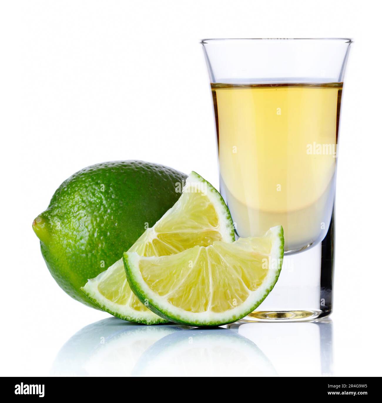 Oro tequila shot con calce isolati su sfondo bianco Foto Stock