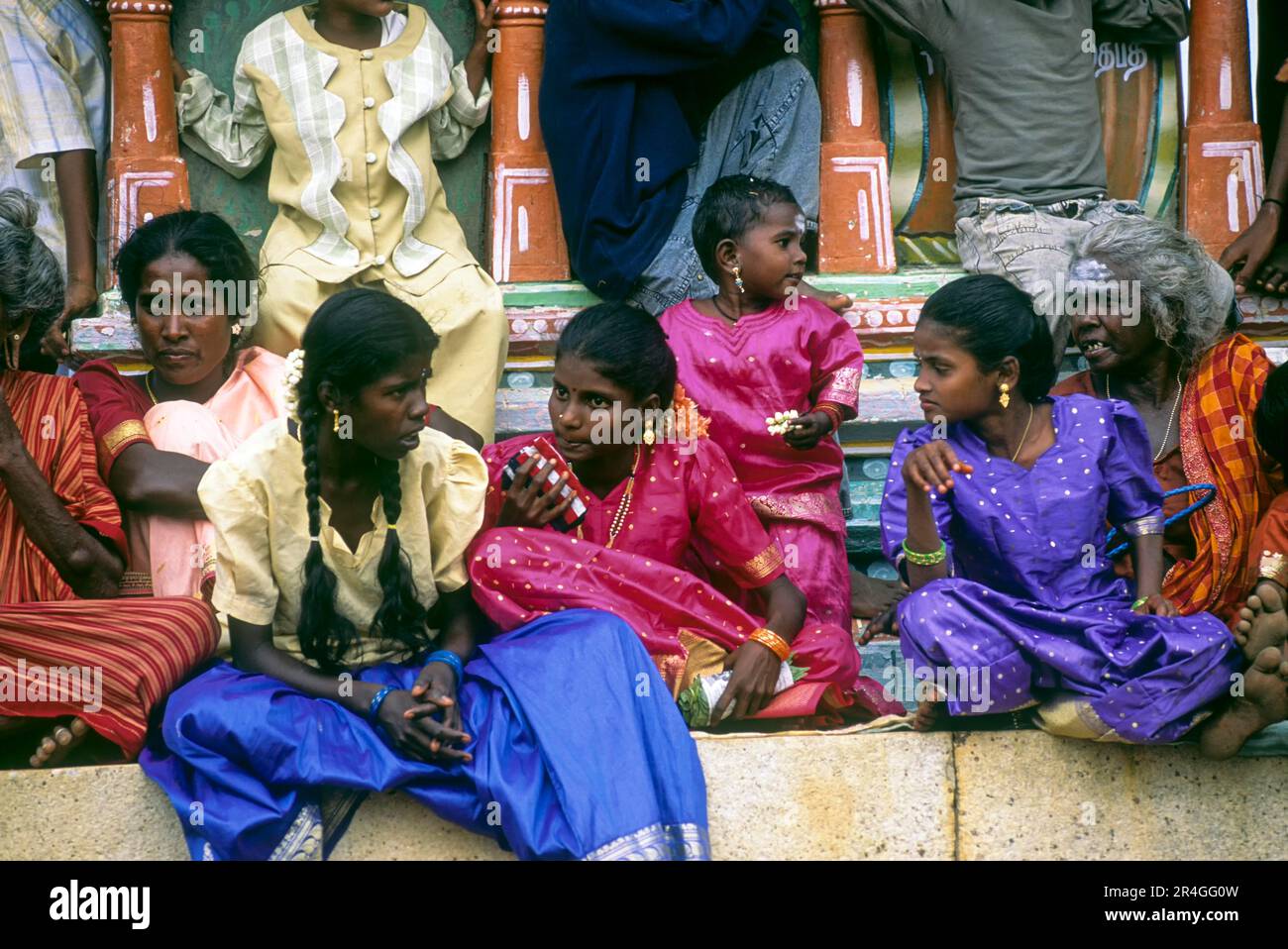 Ragazze e donne del villaggio seduti sotto i piedi della statua Ayyanar durante il festival Sivarathri in un villaggio in Tamil Nadu, India, Asia Foto Stock