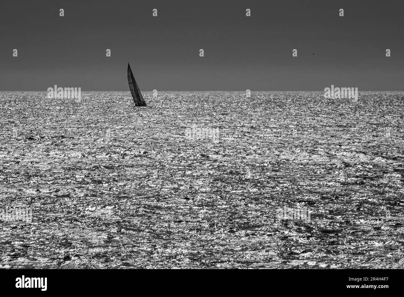 Barca a vela in un mare scintillante. Minimalista. Costa del portogallo settentrionale. Foto Stock