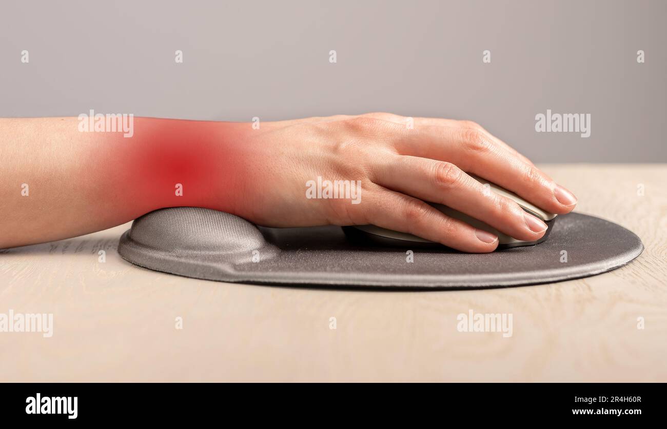 Dolore al polso, concetto di dolore. Mano sdraiata sul mouse del computer con tampone di supporto in gel. Foto Stock