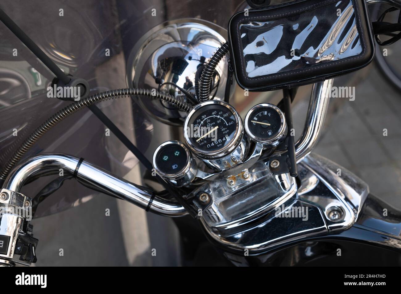 Motocicletta classica con orologi lucidi, volante, copertura telefono e altri dettagli. Vista dall'alto, concentrarsi sul tachimetro Foto Stock