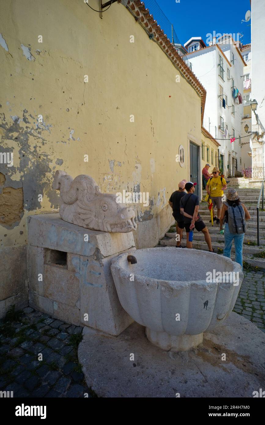 Una guida turistica con turisti nel quartiere Alfama di Lisbona, dove il vecchio incontra il nuovo Foto Stock