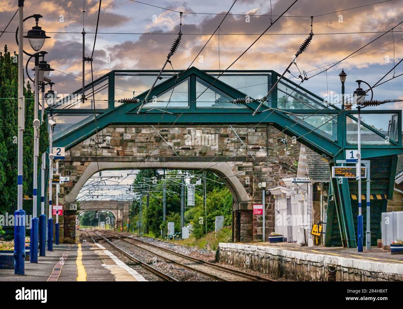 Guardando attraverso il piccolo ponte di pietra lungo il convoglio ferroviario tracce, Drem stazione ferroviaria, East Lothian, Scozia, Regno Unito Foto Stock