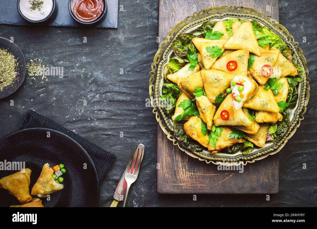 Deliziosa Samosa vegetariana servita con salsa di pomodoro e yogurt. Vista dall'alto con primo piano. Foto Stock