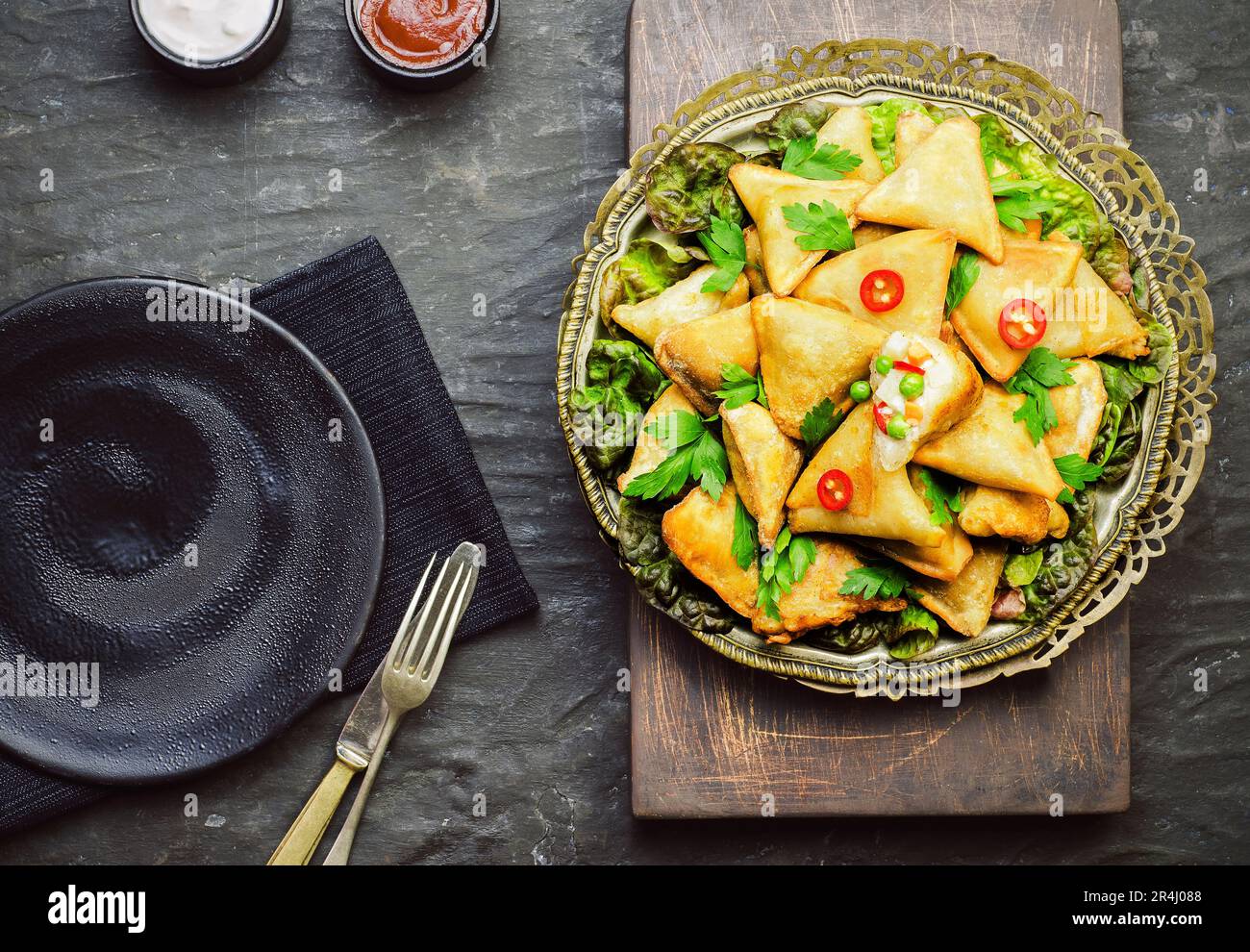Deliziosa Samosa vegetariana servita con salsa di pomodoro e yogurt. Vista dall'alto con primo piano. Foto Stock