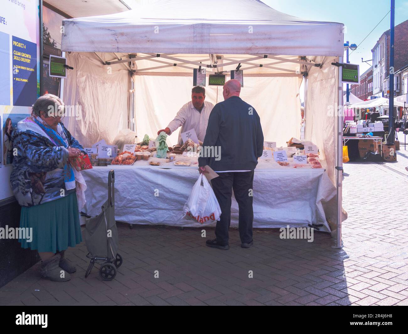 Una coppia che acquista da una bancarella specializzata del mercato del pesce a Redcar Market North Yorkshire Foto Stock
